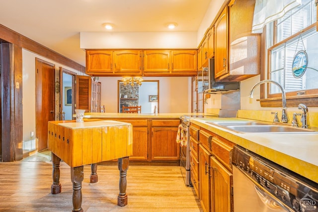 176 High Rock Rd, West Coxsackie, NY 12192 - kitchen featuring stainless steel dishwasher, a sink, light countertops, light wood-style floors, and brown cabinetry