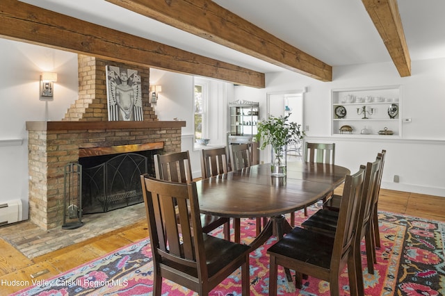 202 Buckwheat Bridge Rd, Germantown, NY 12526 - dining area with hardwood / wood-style floors, a fireplace, beam ceiling, and baseboard heating