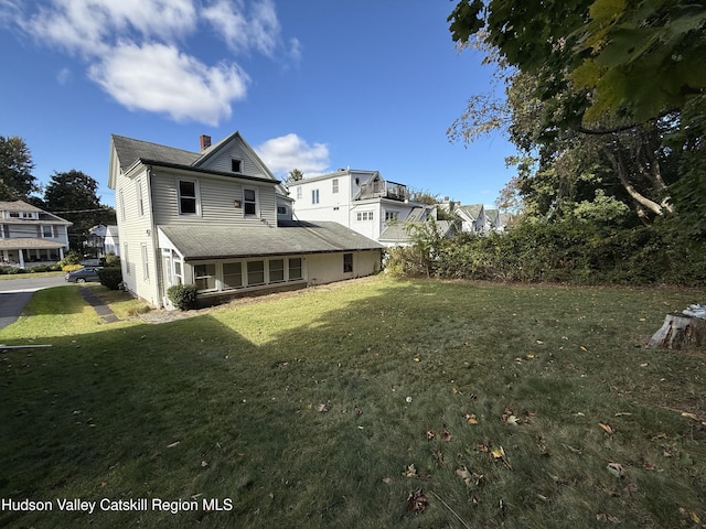 rear view of house featuring a lawn