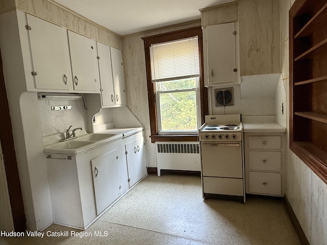 kitchen with radiator, sink, white range, washer / clothes dryer, and white cabinets