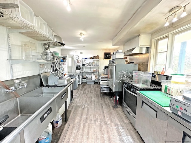 kitchen featuring white cabinets, gas range, and light hardwood / wood-style floors