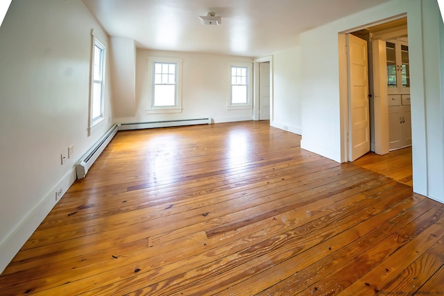 spare room featuring a baseboard radiator and light wood-type flooring