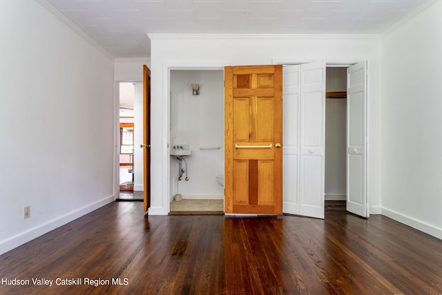 unfurnished bedroom featuring dark wood-type flooring and ornamental molding