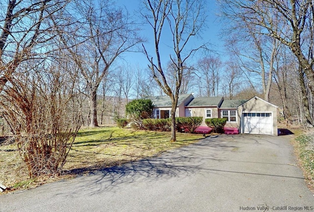 single story home with a garage and a front lawn