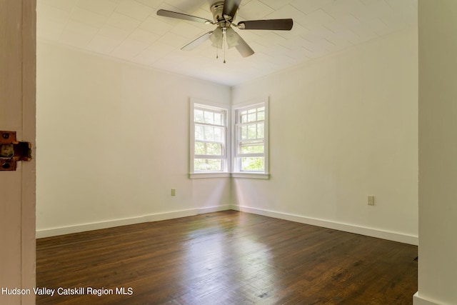 spare room with dark hardwood / wood-style flooring and ceiling fan