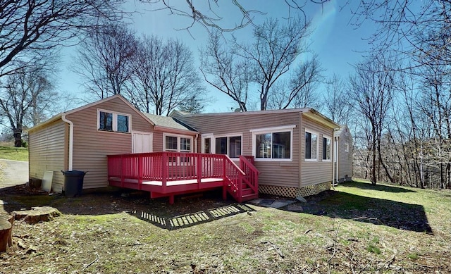 rear view of property featuring a lawn and a wooden deck