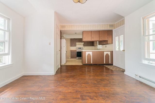 kitchen with baseboard heating, dark wood-type flooring, stainless steel stove, and a healthy amount of sunlight