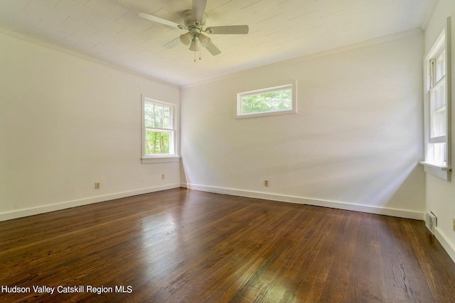 empty room featuring crown molding, ceiling fan, and dark wood-type flooring