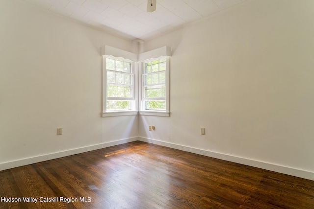 empty room with dark hardwood / wood-style flooring