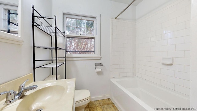 full bathroom featuring toilet, tiled shower / bath, and sink