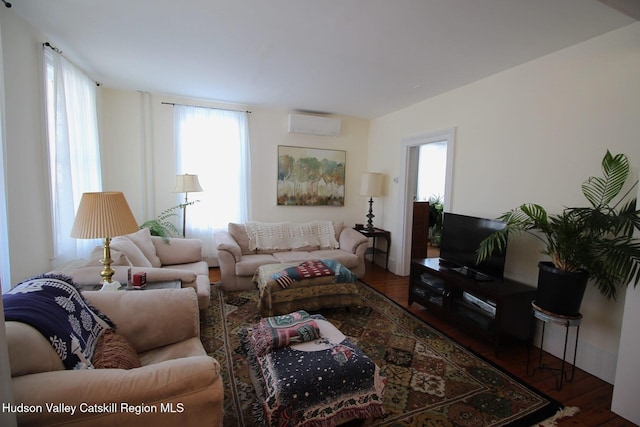 living area with dark wood-style flooring and a wall mounted AC