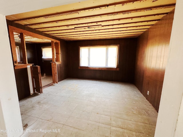 spare room featuring wood walls