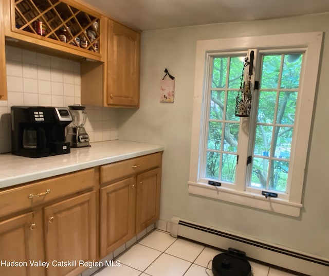 kitchen featuring baseboard heating, decorative backsplash, and light tile patterned floors