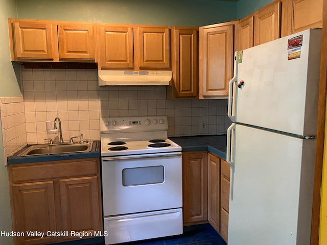 kitchen featuring decorative backsplash, white appliances, dark tile patterned flooring, and sink