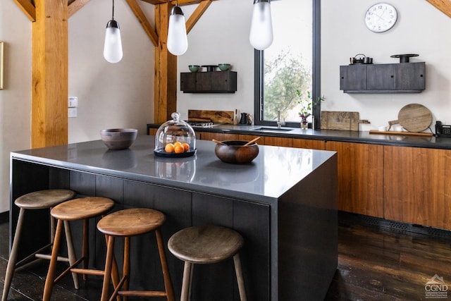 890 Bald Mountain Rd, Austerlitz, NY 12017 - kitchen with a sink, dark countertops, brown cabinetry, and a kitchen bar