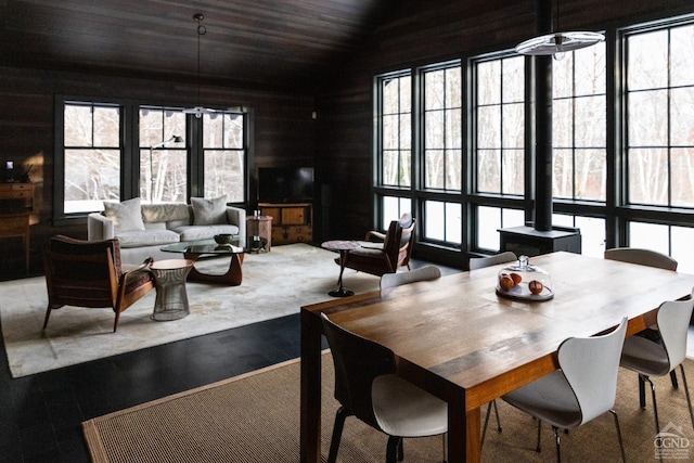890 Bald Mountain Rd, Austerlitz, NY 12017 - dining area with healthy amount of natural light, lofted ceiling, a wood stove, wood finished floors, and wood walls