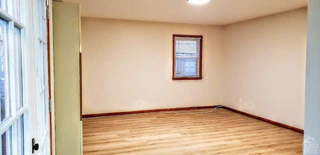 unfurnished room with light wood finished floors and baseboards