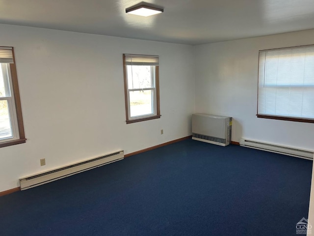 unfurnished room with baseboard heating, a baseboard radiator, baseboards, and dark colored carpet