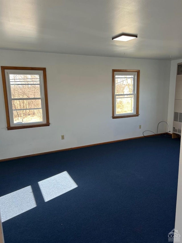 unfurnished room with carpet flooring and baseboards