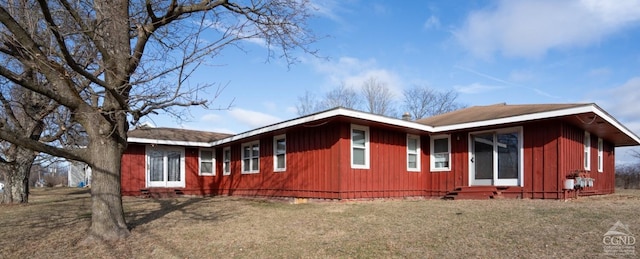 view of side of home featuring entry steps, crawl space, and a lawn