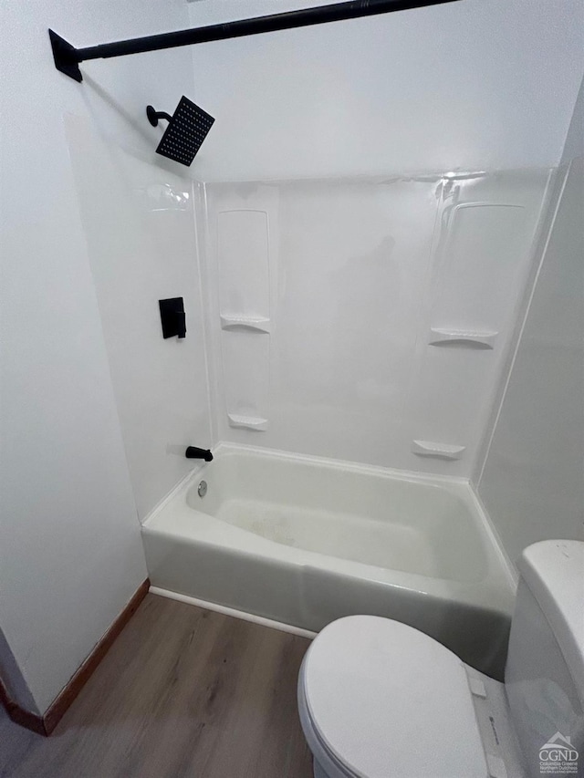 full bathroom featuring toilet, wood finished floors, baseboards, and bathtub / shower combination