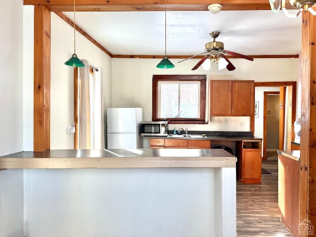 2435 Rte 145, Durham, NY 12423 - kitchen featuring freestanding refrigerator, stainless steel microwave, a sink, brown cabinets, and a peninsula
