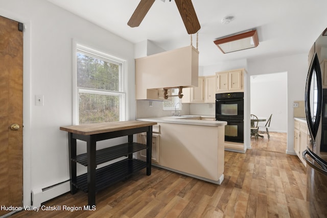 146 Sherman Rd, Kingston, NY 12401 - kitchen with dobule oven black, a peninsula, baseboard heating, light countertops, and light wood finished floors