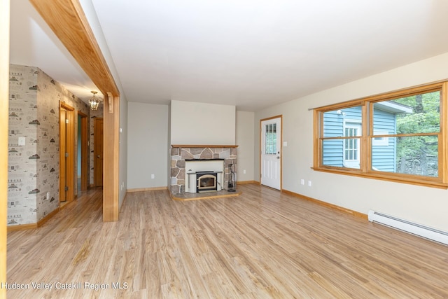 unfurnished living room featuring beamed ceiling, light wood-type flooring, a stone fireplace, and a baseboard heating unit