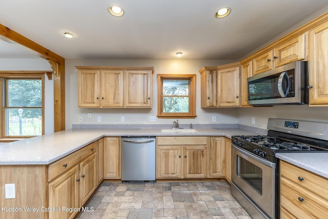 kitchen featuring kitchen peninsula, sink, stainless steel appliances, and light brown cabinets