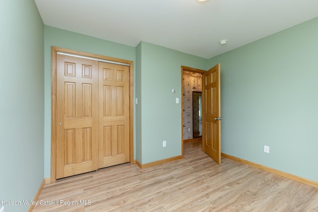 unfurnished bedroom with a closet and light hardwood / wood-style flooring