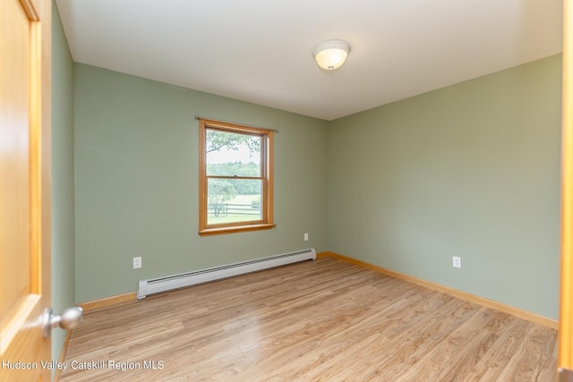 spare room with light hardwood / wood-style floors and a baseboard heating unit