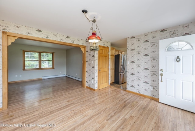 foyer entrance with light hardwood / wood-style floors and a baseboard heating unit