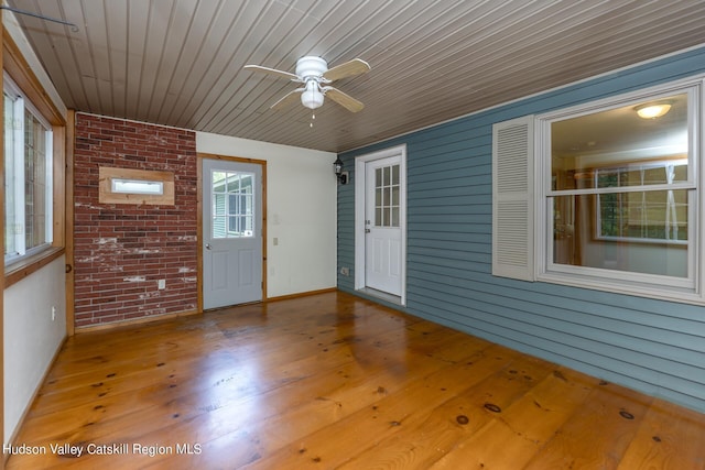 unfurnished sunroom with ceiling fan and wooden ceiling