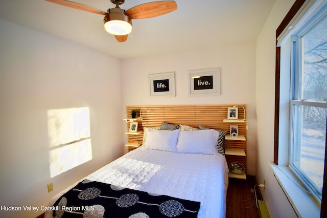 bedroom with dark hardwood / wood-style floors and ceiling fan