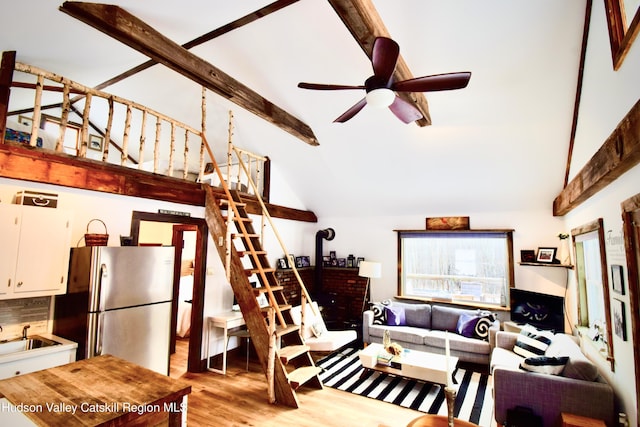 living room with high vaulted ceiling, sink, ceiling fan, light wood-type flooring, and beam ceiling