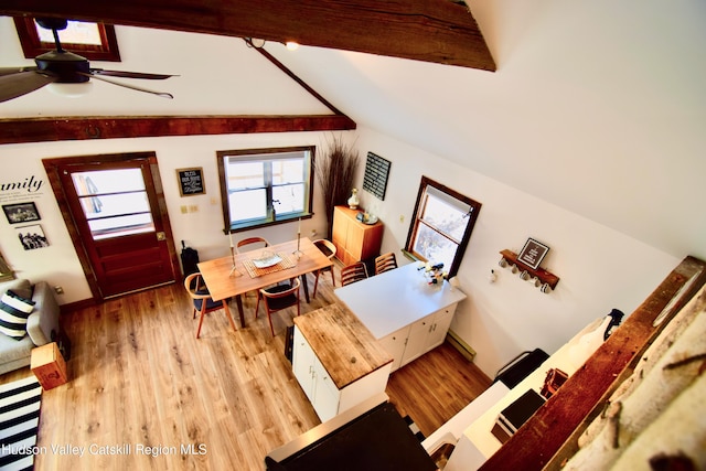 dining area with vaulted ceiling with beams, light wood-type flooring, and ceiling fan