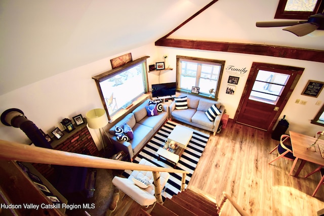 living room with ceiling fan, vaulted ceiling, and hardwood / wood-style flooring