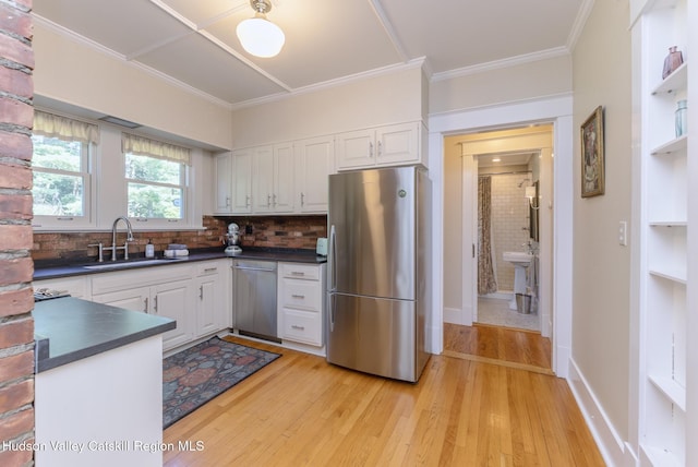 280 Pitcher Ln, Red Hook, NY 12571 - kitchen featuring appliances with stainless steel finishes, dark countertops, light wood-style floors, white cabinetry, and ornamental molding
