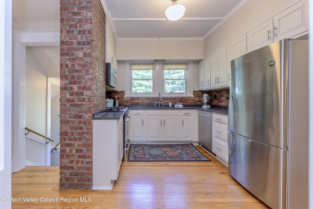 280 Pitcher Ln, Red Hook, NY 12571 - kitchen with stainless steel appliances, dark countertops, crown molding, white cabinets, and light wood-style flooring