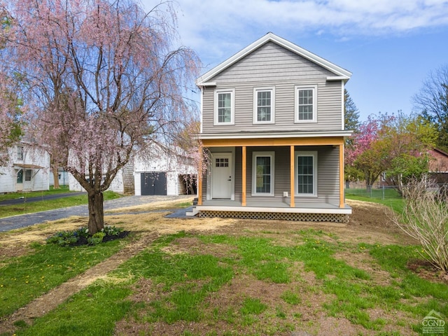 143 Grand St, Schoharie, NY 12157 - view of front facade with covered porch, driveway, fence, and a garage