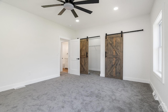 143 Grand St, Schoharie, NY 12157 - unfurnished bedroom with a barn door, carpet, baseboards, and recessed lighting