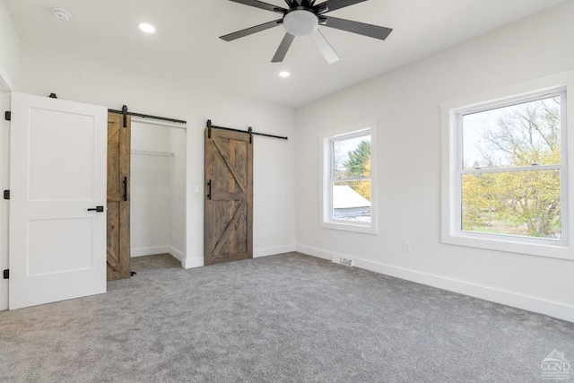 143 Grand St, Schoharie, NY 12157 - unfurnished bedroom featuring a barn door, carpet flooring, recessed lighting, baseboards, and a ceiling fan