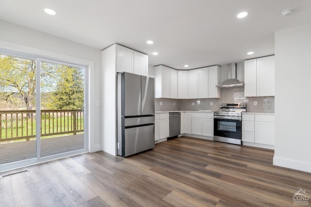 143 Grand St, Schoharie, NY 12157 - kitchen featuring appliances with stainless steel finishes, wall chimney exhaust hood, decorative backsplash, light countertops, and white cabinets