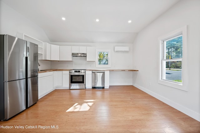 kitchen with white cabinetry, appliances with stainless steel finishes, and vaulted ceiling