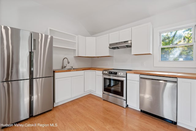 kitchen featuring sink, vaulted ceiling, appliances with stainless steel finishes, light hardwood / wood-style floors, and white cabinets