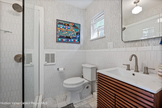 bathroom featuring tile walls, vanity, toilet, and tiled shower