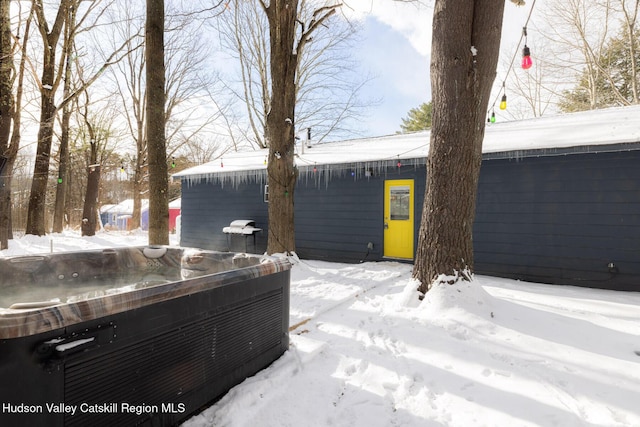 yard layered in snow featuring a hot tub