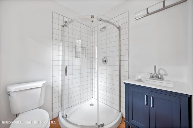 bathroom featuring vanity, toilet, and a shower with shower door