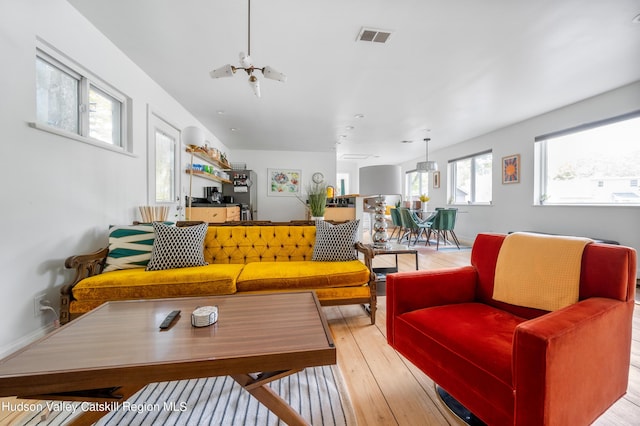 living room featuring an inviting chandelier and light wood-type flooring