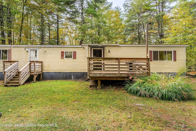 rear view of house with a yard and a deck